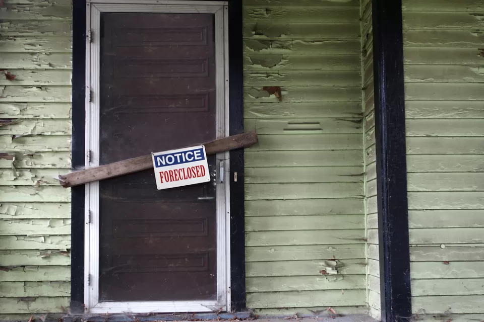 Vacant home with foreclosure sign.